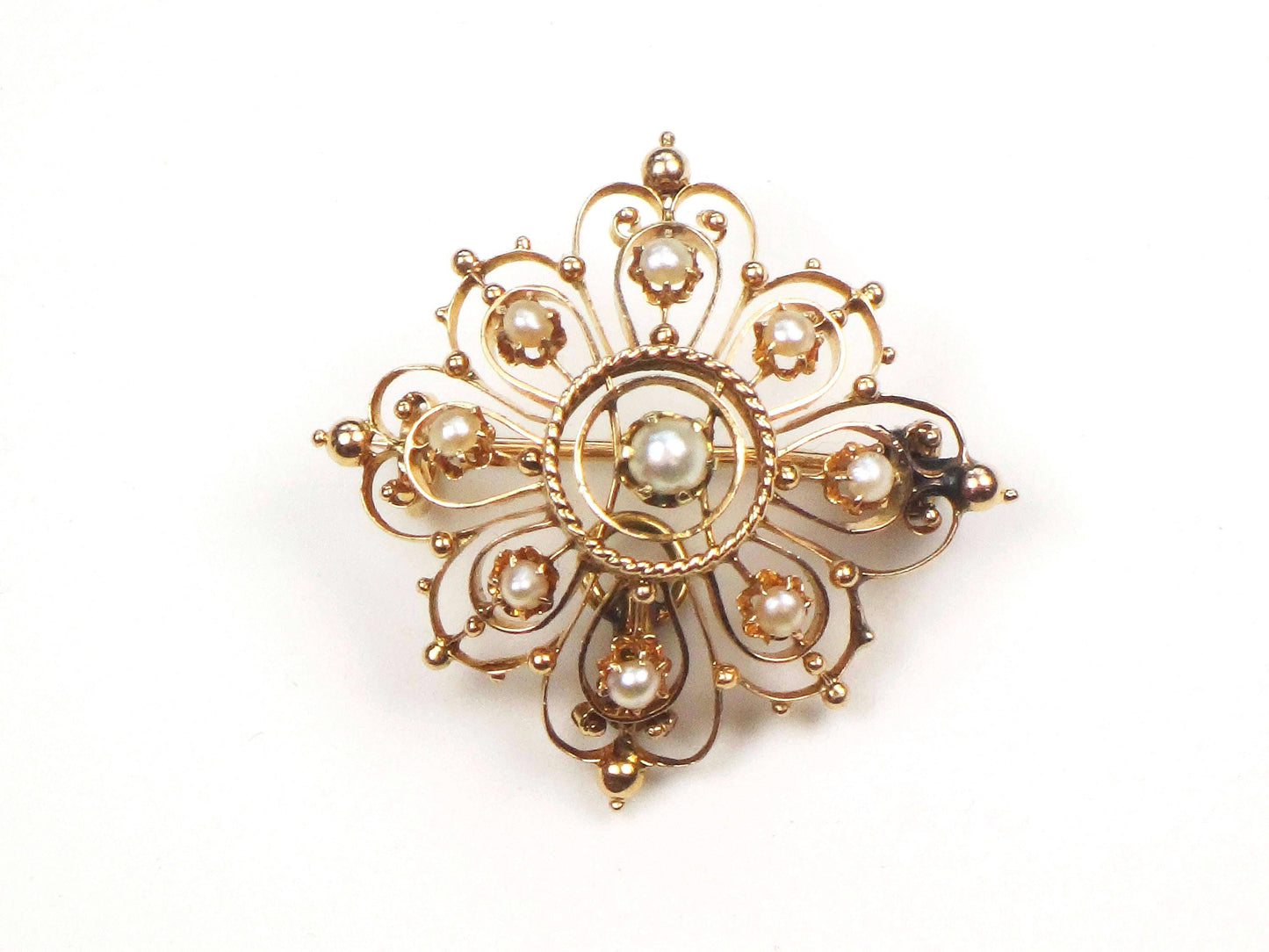 Vintage Victorian 14k Yellow Gold Pearl Pendant Pin, Antique June Birthstone Pendant. A gold and pearl brooch. The brooch is made of delicate filigree work and features eight small pearls around the outer edge and a larger pearl in the center.